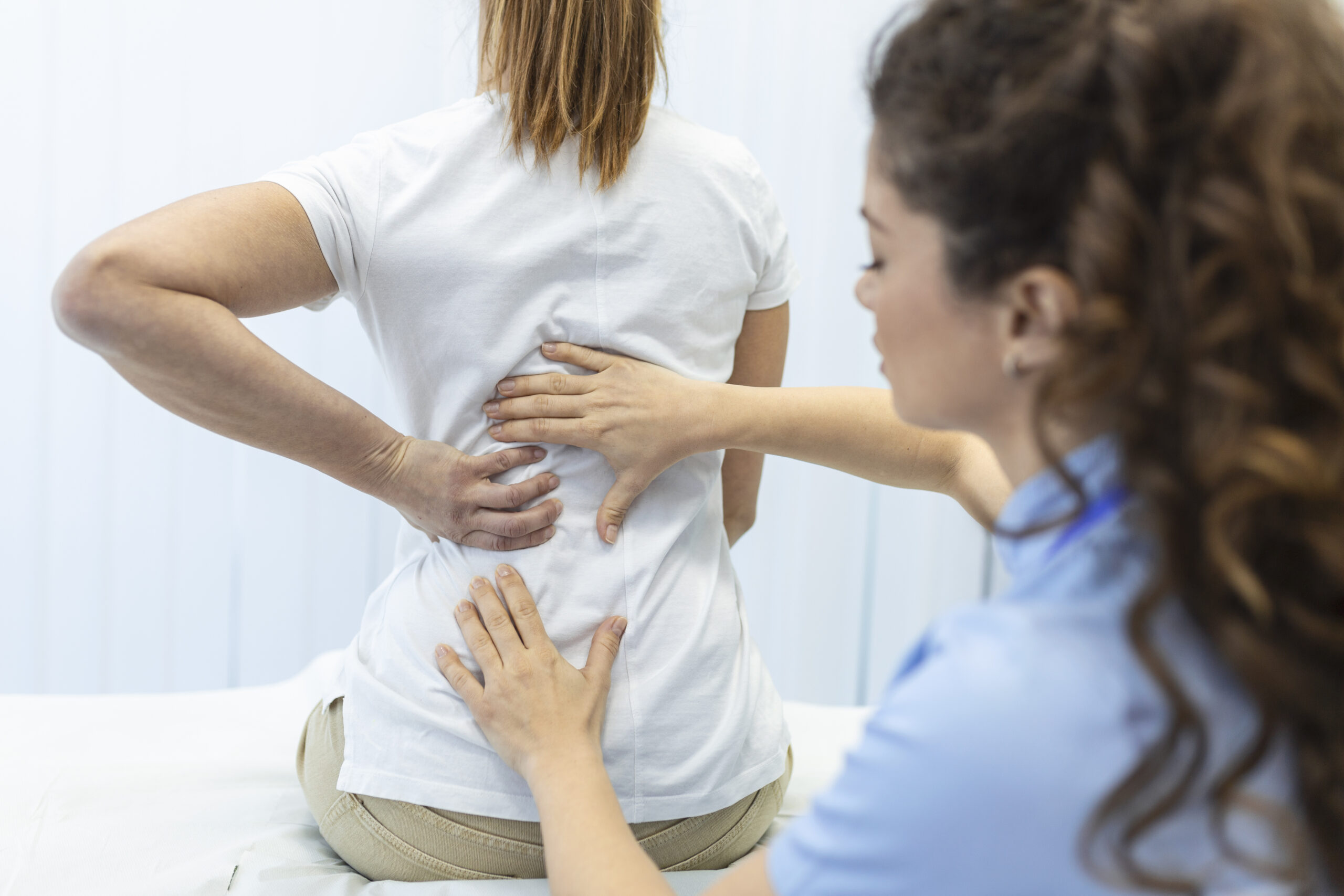 Chiropractor performing spinal assessment on patient